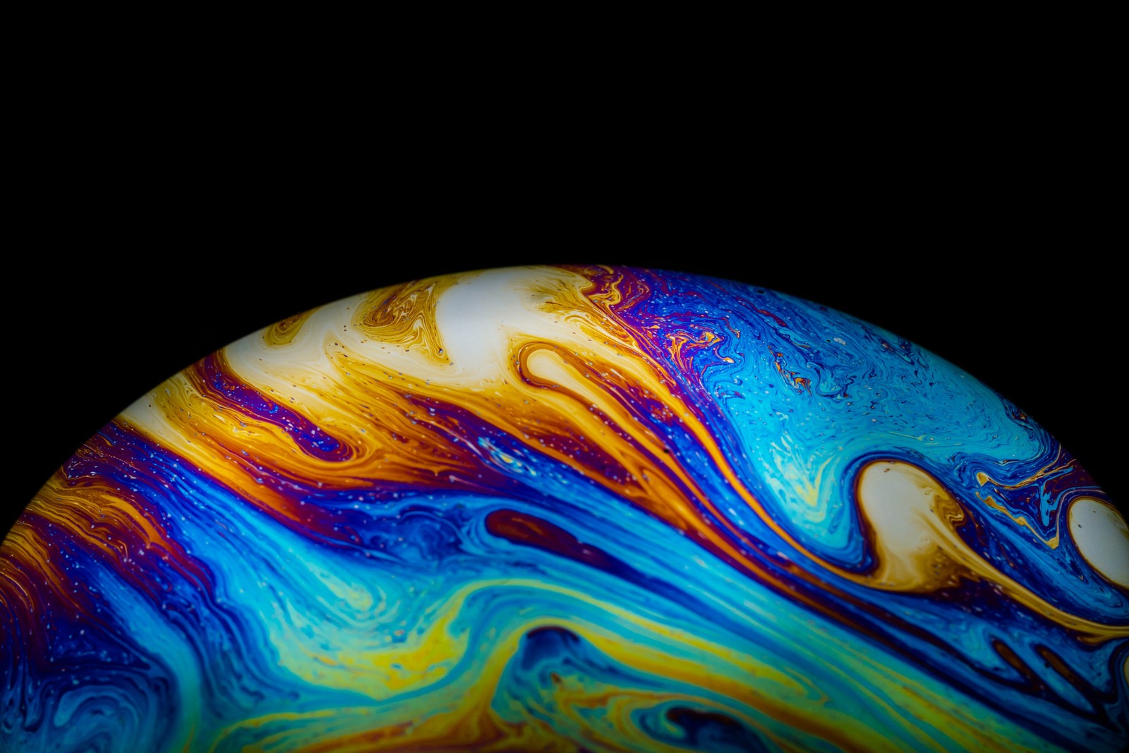 A close up of a colorful marble with a black background (soap bubble, planet, hdr, macro, aqua art)