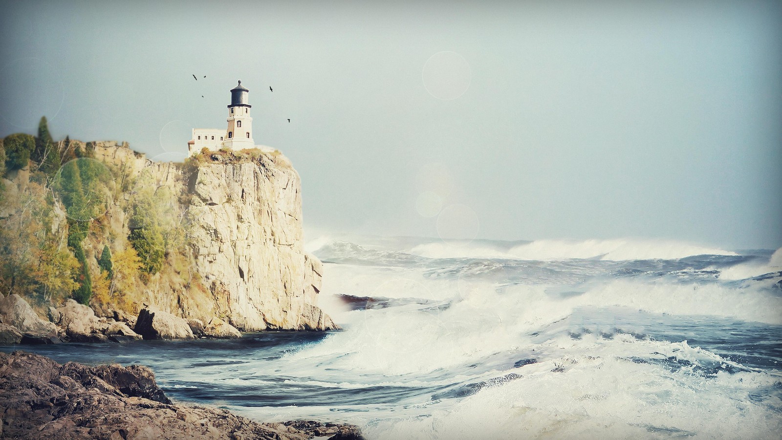 Há um farol em um penhasco com um arco-íris no céu (água, oceano, onda, onda de vento, costa)