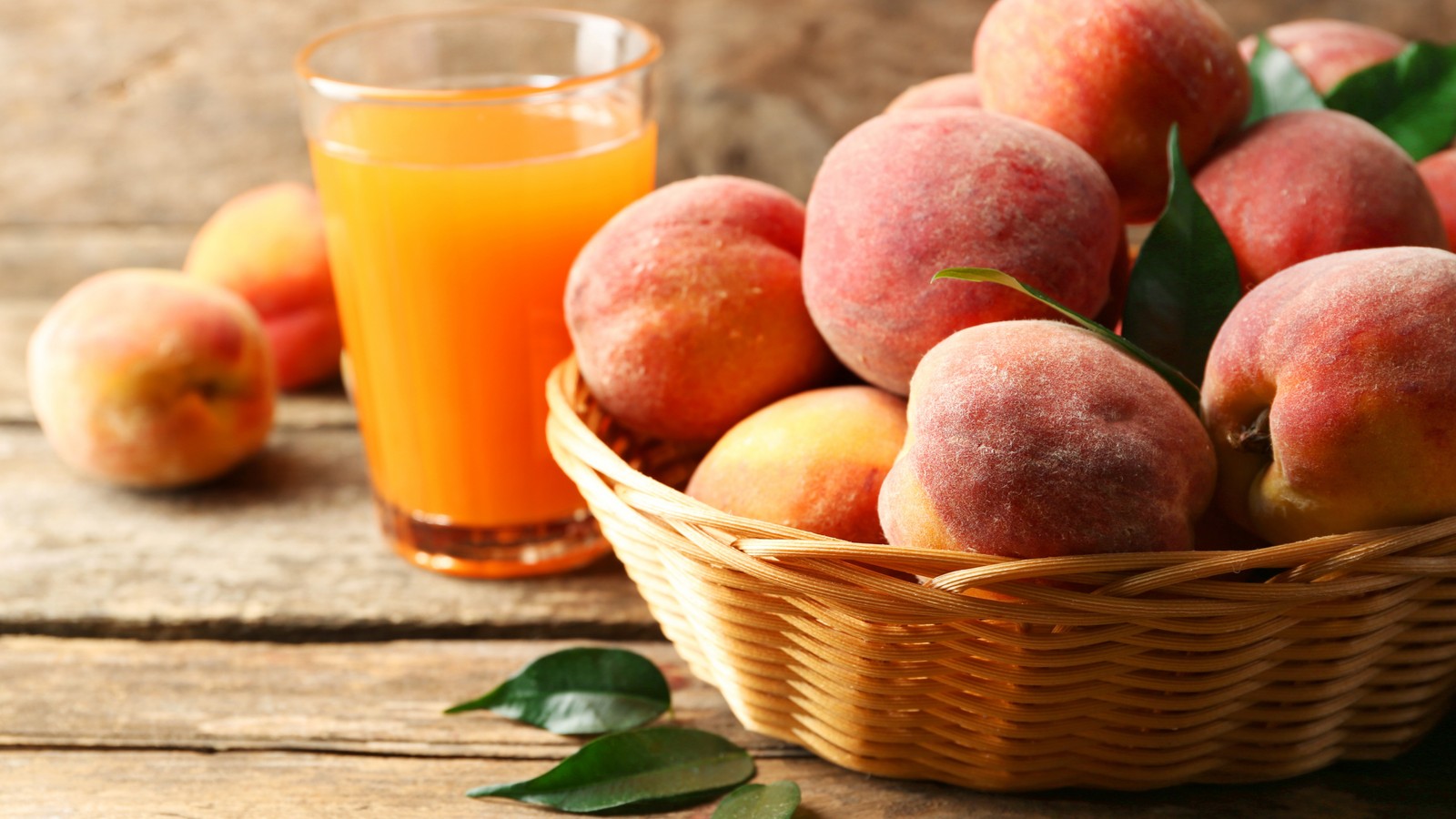 Il y a un panier de pêches et un verre de jus d'orange (pêche, fruit, nourriture, vaisselle, clémentine)