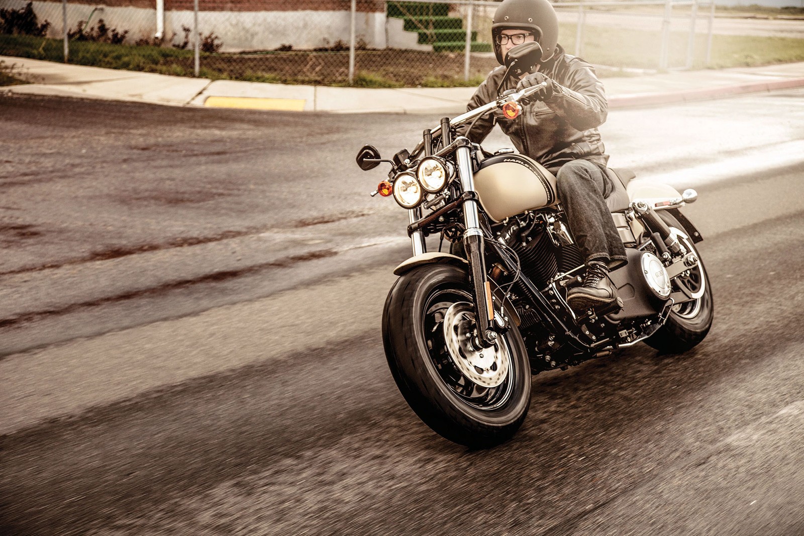 Hay un hombre montando una motocicleta por la calle en una carretera mojada (motocicleta, motocicleta personalizada, neumático de automóvil, motociclismo, crucero)