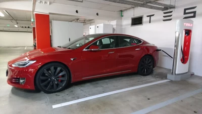 Tesla Model S rojo cargando en una estación Supercharger