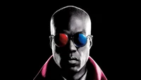 Morpheus dans The Matrix Resurrections : Une silhouette frappante sur un fond noir, mettant en avant Yahya Abdul-Mateen II avec des lunettes de soleil rouges et bleues emblématiques, incarnant l'essence du film de 2022.