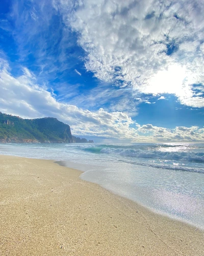 Serene Beachscape Under Billowy Cumulus Clouds