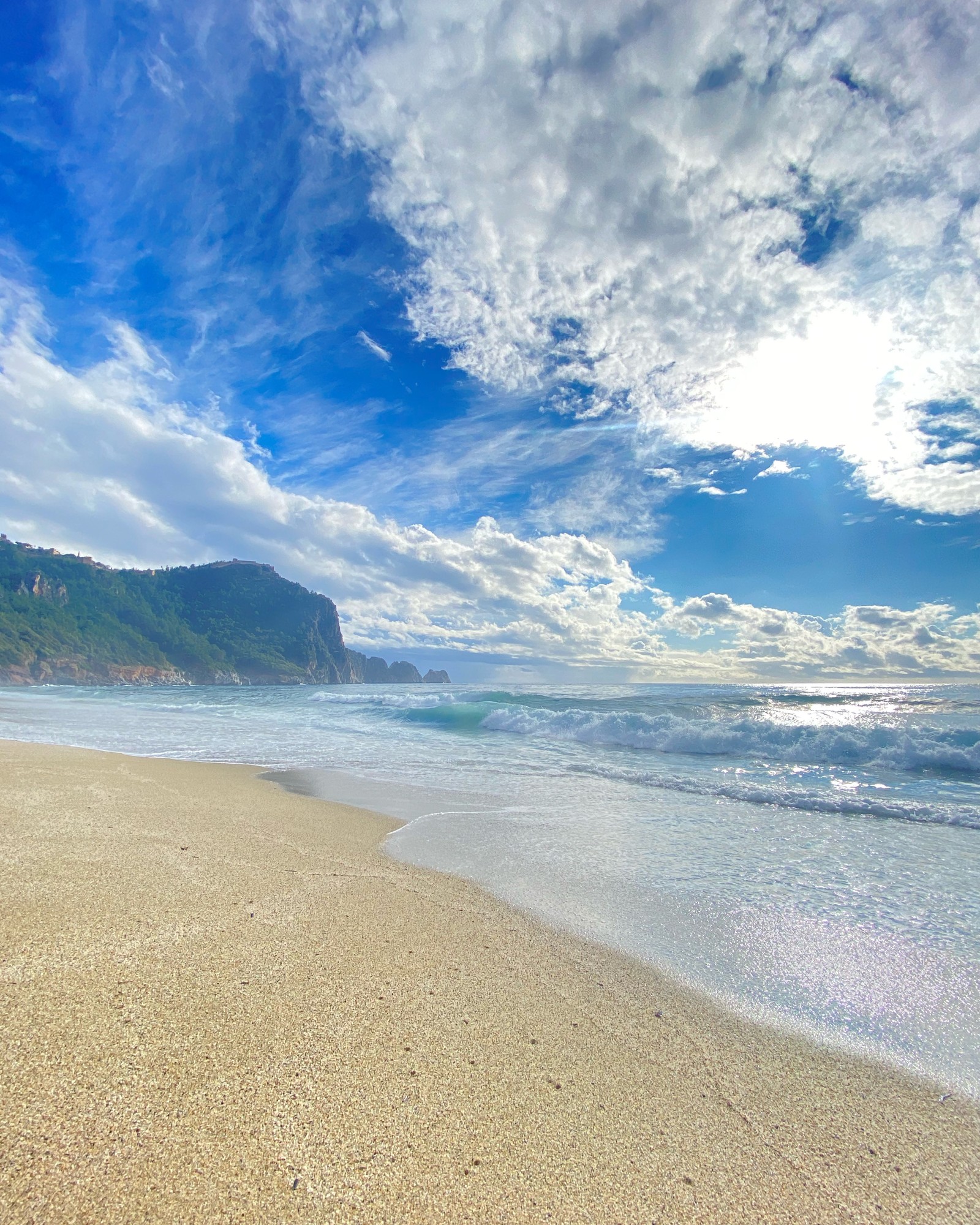 Il y a une planche de surf qui est posée sur la plage (nuage, eau, atmosphère, bleu, plage)