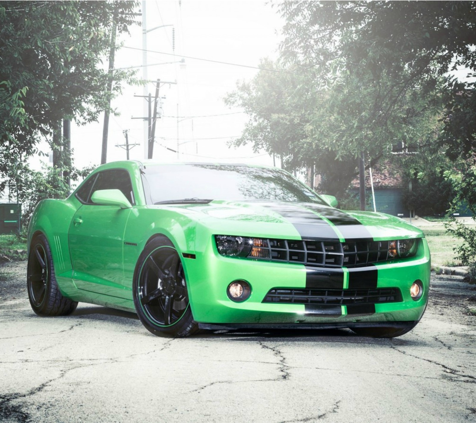 A close up of a green car parked on a street (car, green)