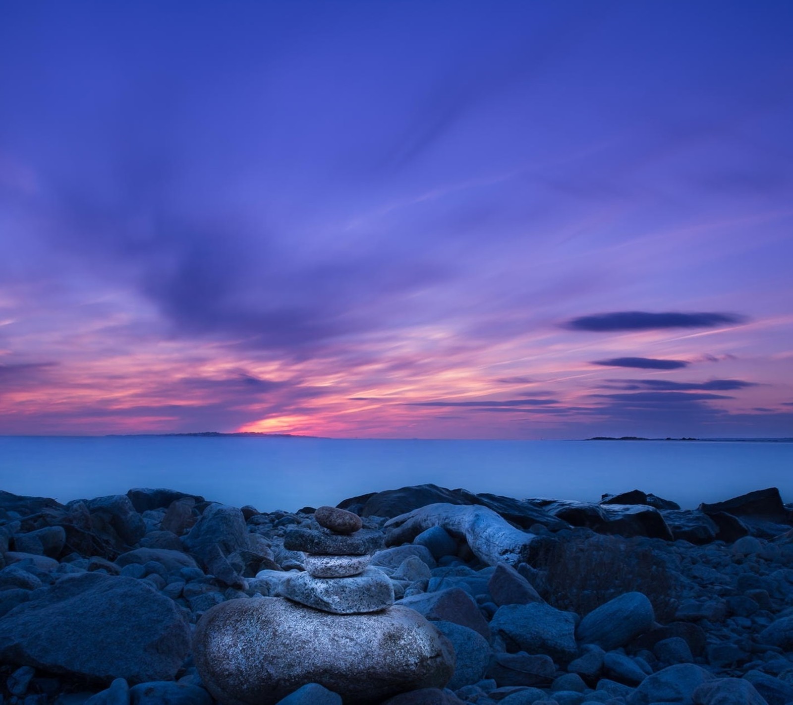 Vue sur une plage rocheuse avec un coucher de soleil en arrière-plan (paysage, nature)