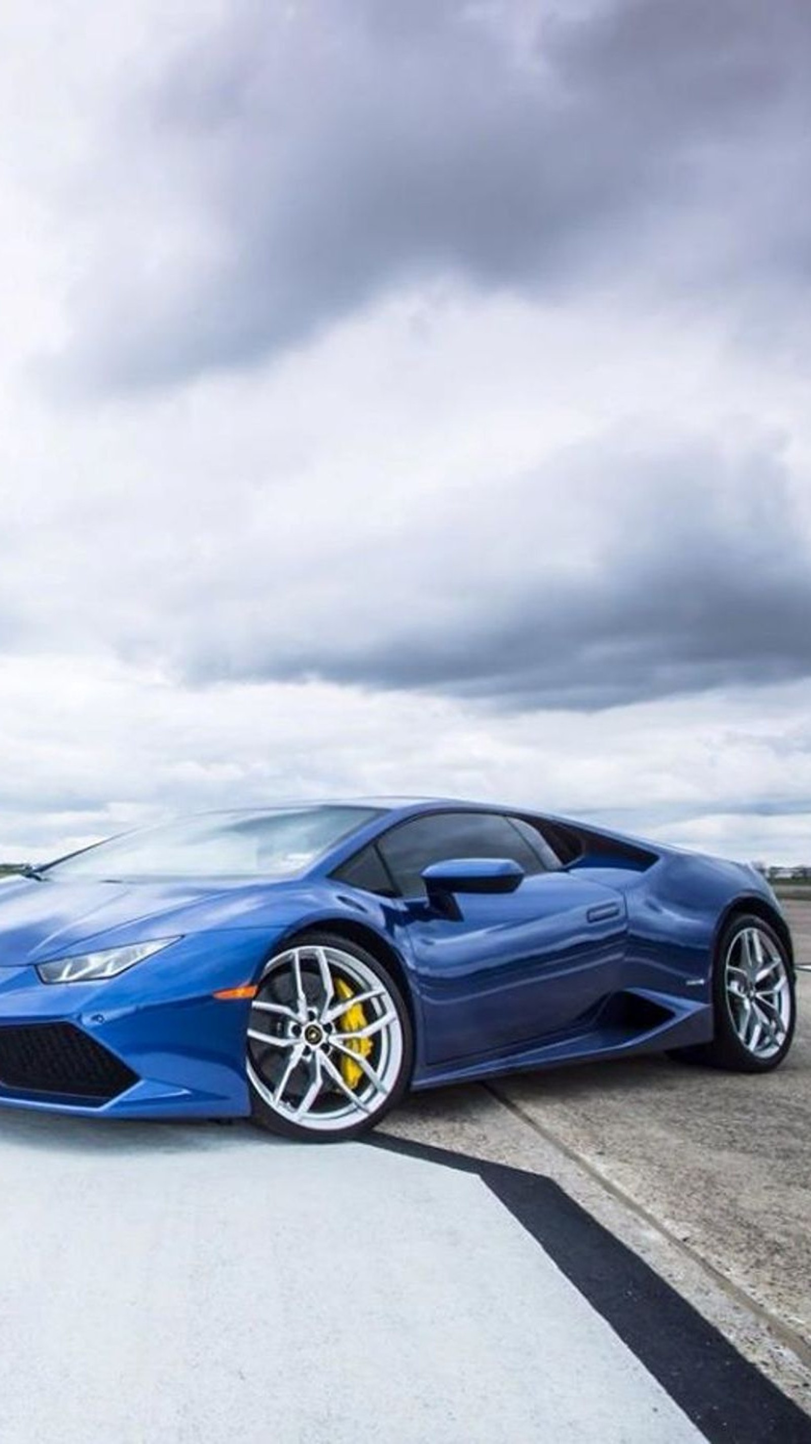 A blue lamb sports car parked on a runway with a cloudy sky (blue, car, lamborghini, speed)