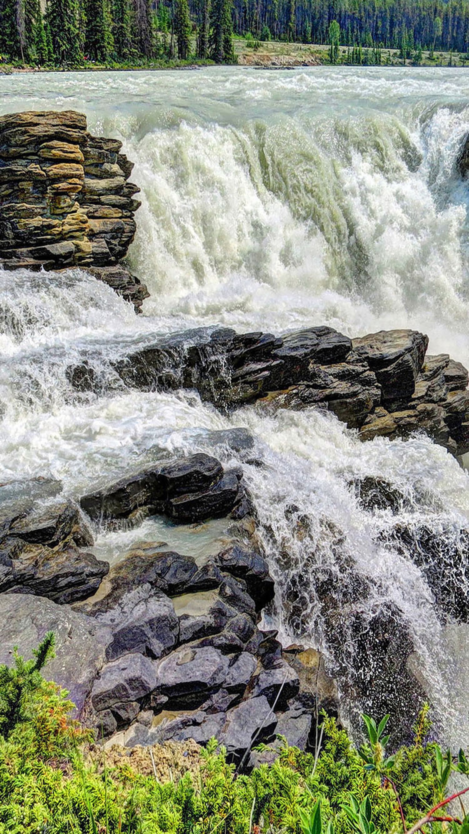 There is a waterfall that is flowing over rocks in the water (fall, water)