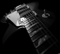 Primer plano en blanco y negro de una guitarra eléctrica, destacando sus intrincados detalles y hardware.