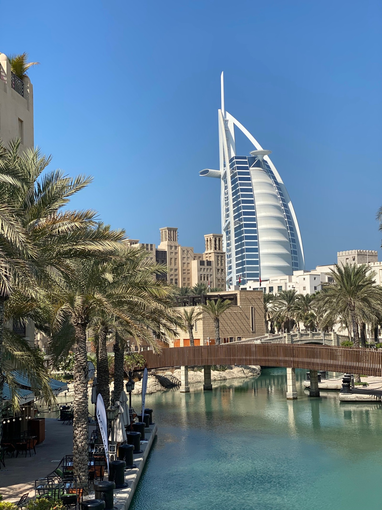 Araffes in the middle of a canal with palm trees and a burjra (dubai, burj al arab, tower block, city, tower)