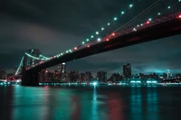 Cenário urbano noturno vibrante da Ponte do Brooklyn iluminada contra o horizonte de Manhattan