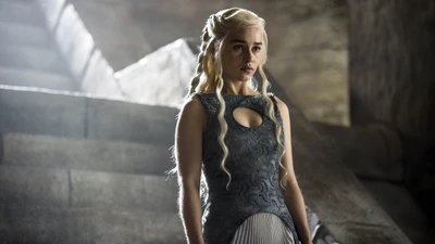 Daenerys Targaryen en un impresionante vestido gris, posando en escalones de piedra con una expresión cautivadora.