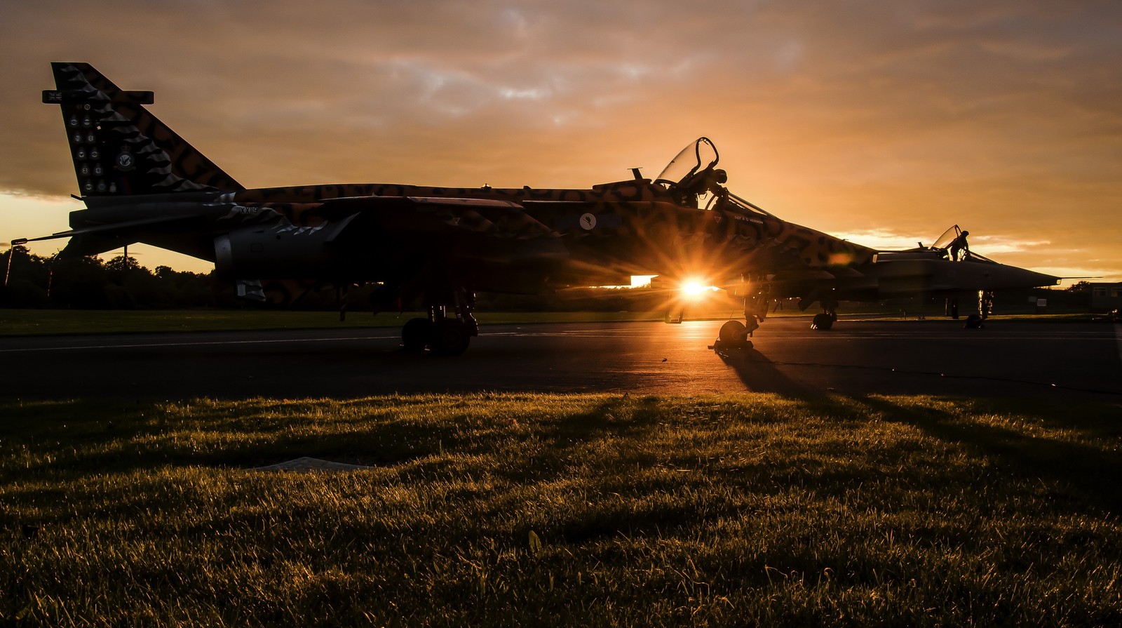 Um jato árabe parado na pista ao pôr do sol com o sol se pondo (aeronave, aviação, força aérea, aeronave militar, engenharia aeroespacial)