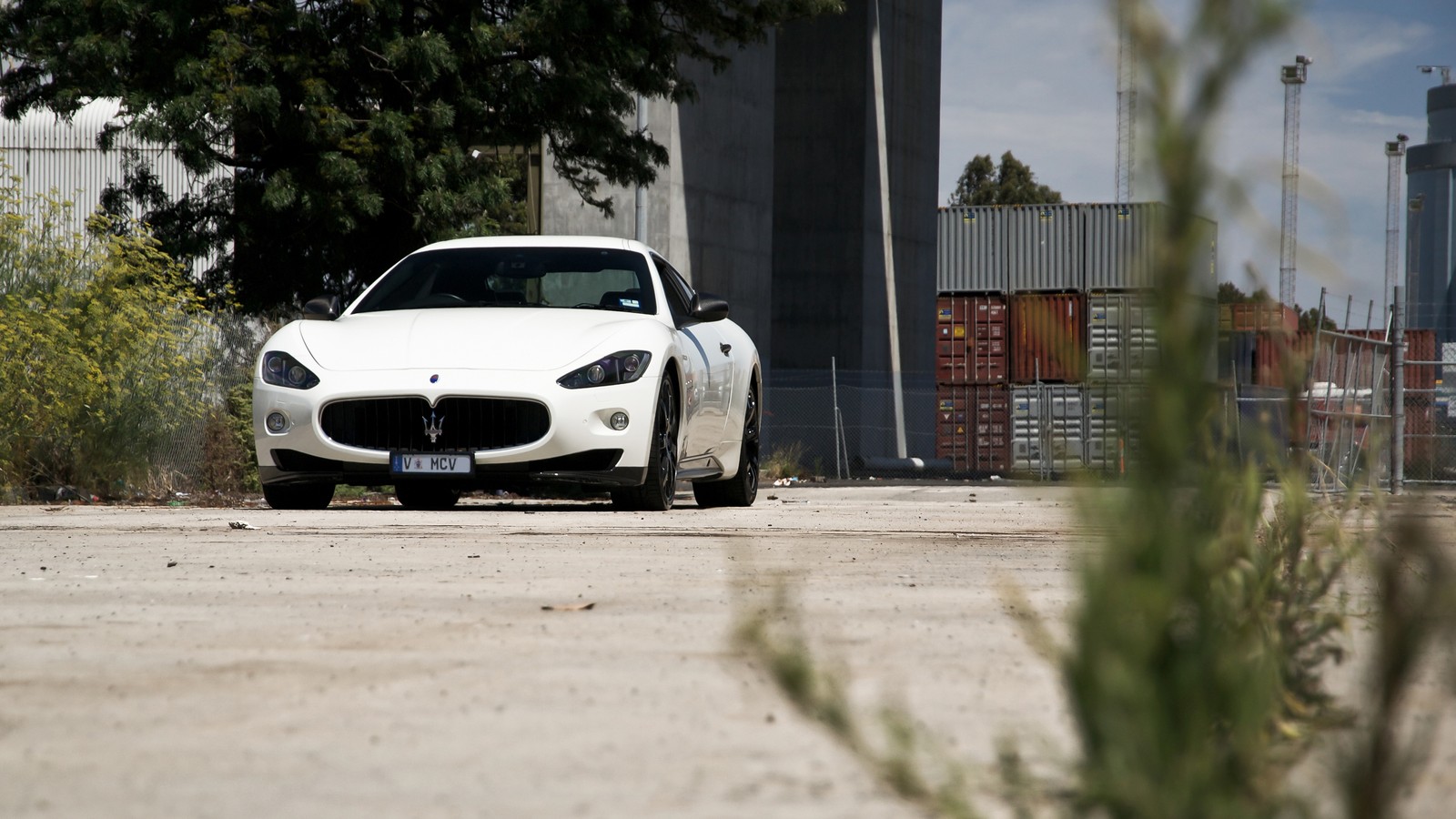 Ein weißes auto ist vor einem hohen gebäude geparkt (maserati, maserati levante, superauto, maserati granturismo, straße)