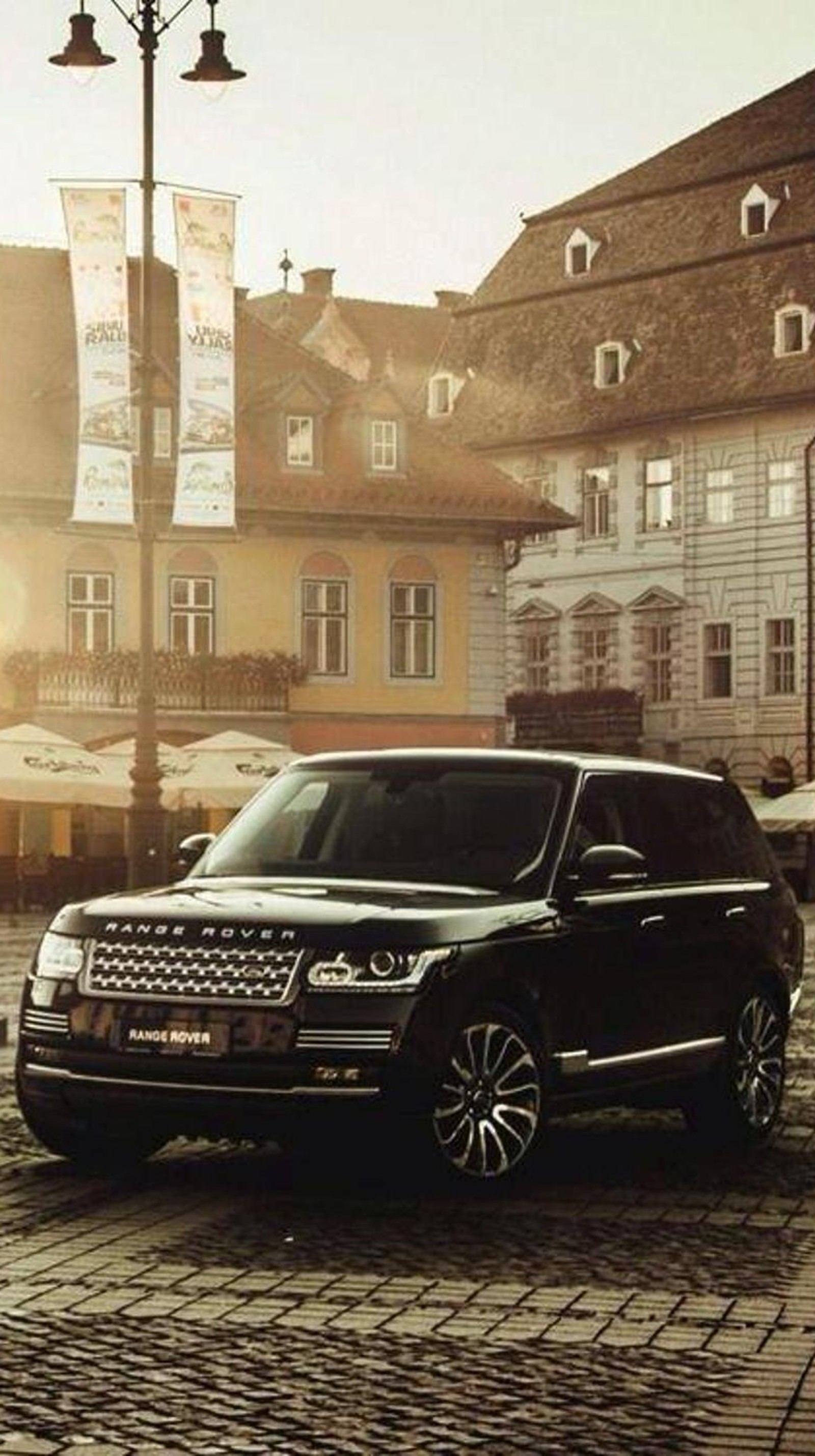 A close up of a black range rover parked on a cobblestone street (black, car, range rover)