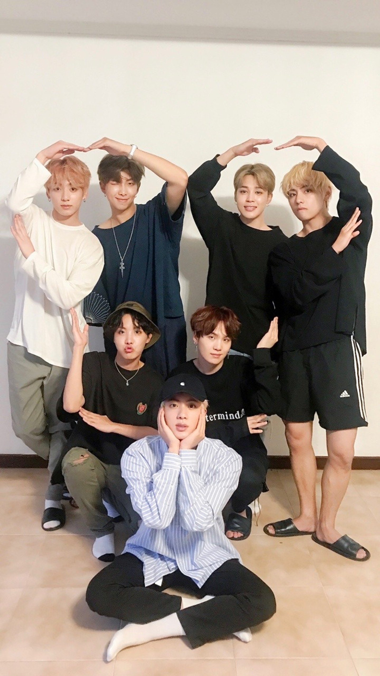 Um grupo de jovens posando para uma foto em uma sala (bts, grupo, kpop)