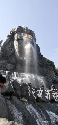 Escultura majestosa de Shiva com cachoeira e significado espiritual