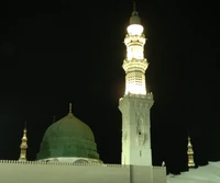 Masjid e Nabwi bei Nacht: Ein majestätischer Blick auf die grüne Kuppel und den beleuchteten Minarett in Medinah