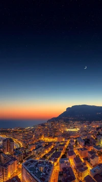 Impresionante vista aérea de una ciudad al anochecer con una luna creciente