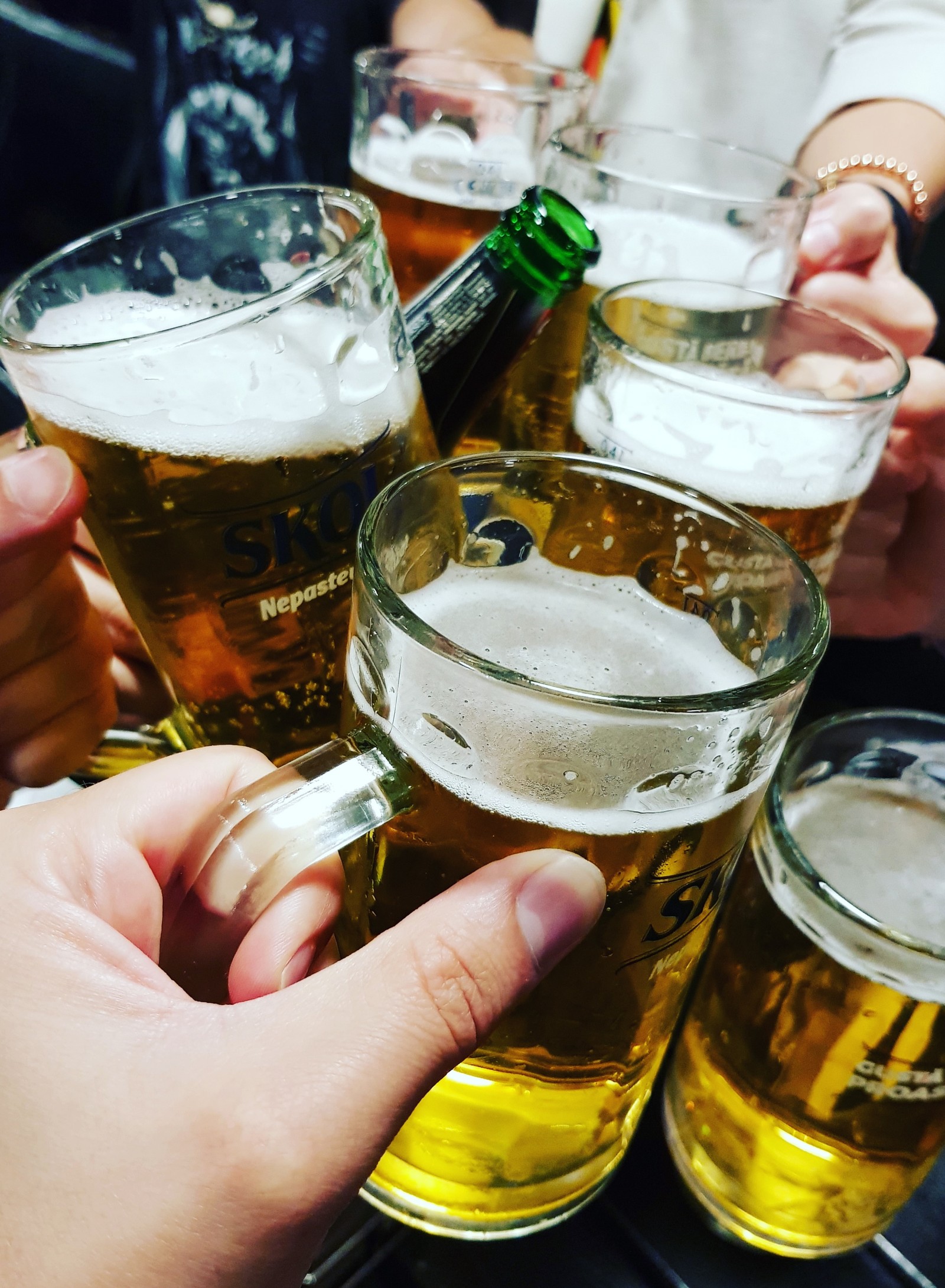 Varias personas brindando con vasos de cerveza en un bar (fiesta, corto, vida, cervezas, amigos)