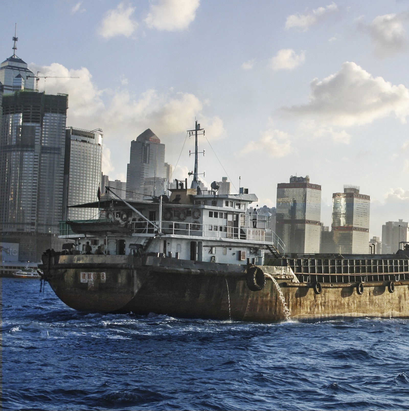 Arafed ship in the water with a city in the background (hong kong, pfurman, piotr furman, ship)