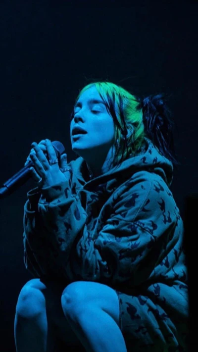 Billie Eilish actuando emocionalmente bajo las luces del escenario