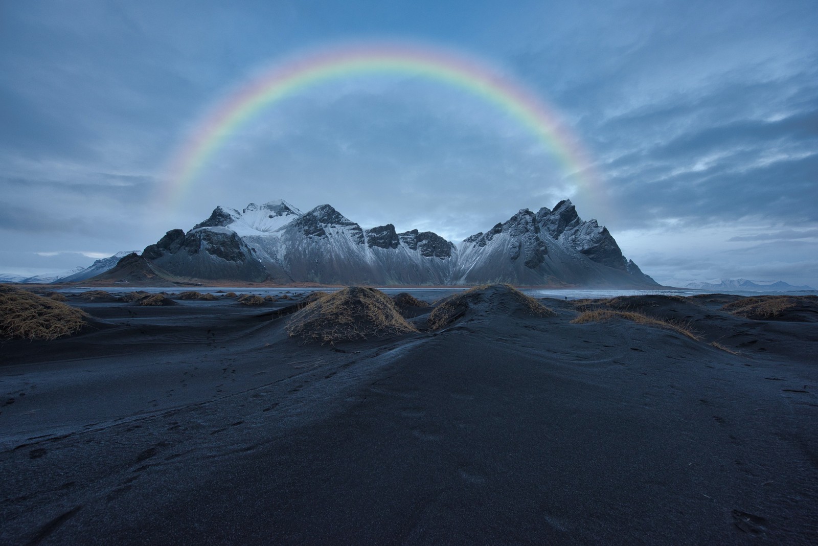 A brightly colored rainbow over a mountain range in iceland (nature, quotation, rainbow, cloud, atmosphere)