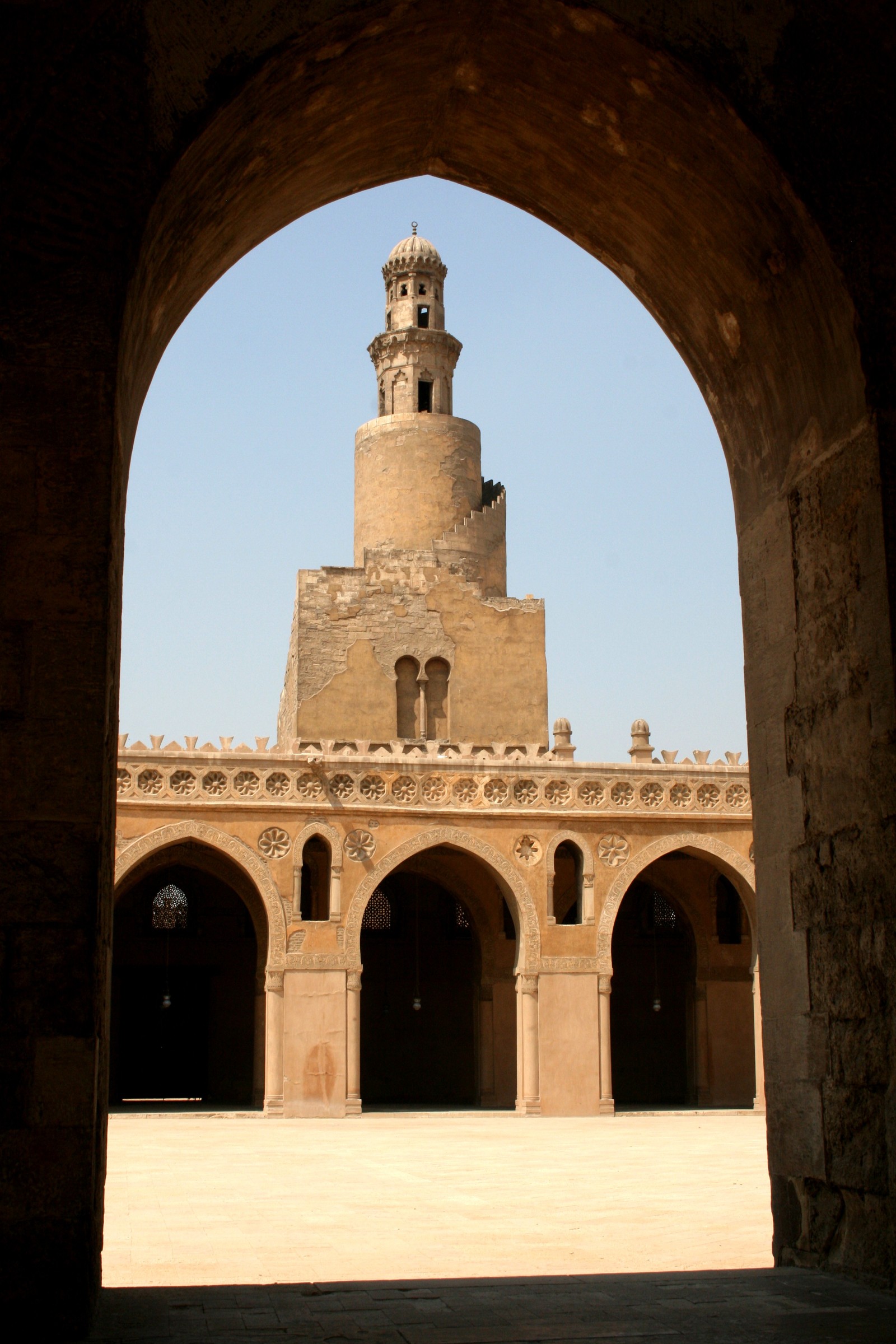 Arabische sicht auf ein gebäude mit einem glockenturm in der mitte (minarett, bogen, historische stätte, gebäude, befestigung)