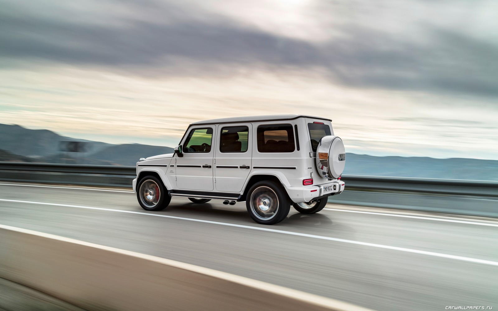 Un mercedes g-class blanc sur une autoroute (voiture, jeep, amg, mercedes amg, extérieur automobile)