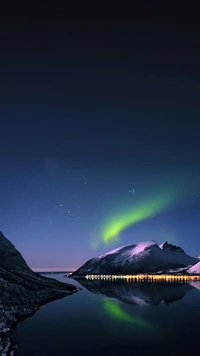 Lago de montaña sereno bajo las auroras boreales