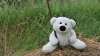 Adorable Plush Teddy Bear Sitting on Hay with a Stick