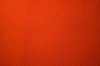 Texturiertes orangefarbenes Textil mit floralem Muster