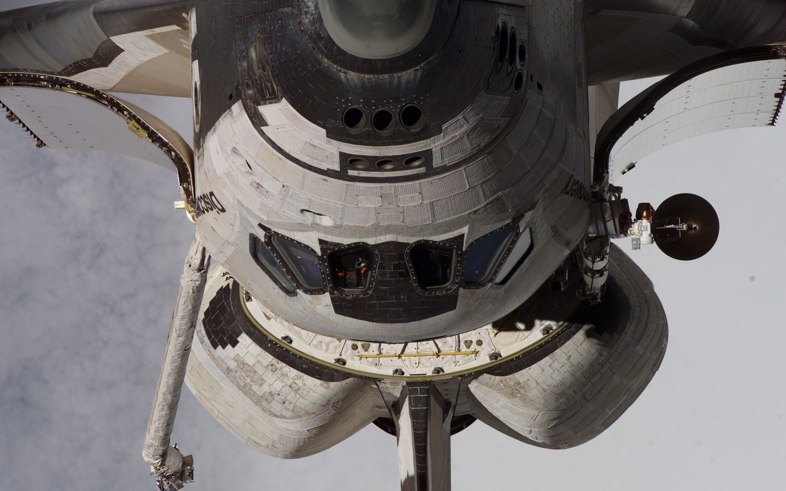 Um close de uma estação espacial com um ônibus espacial ao fundo (ônibus espacial, space shuttle, estação espacial internacional, nasa, espaço)