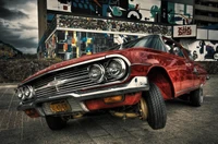 Chevrolet Impala clássico Lowrider com detalhes personalizados contra um fundo de mural vibrante.