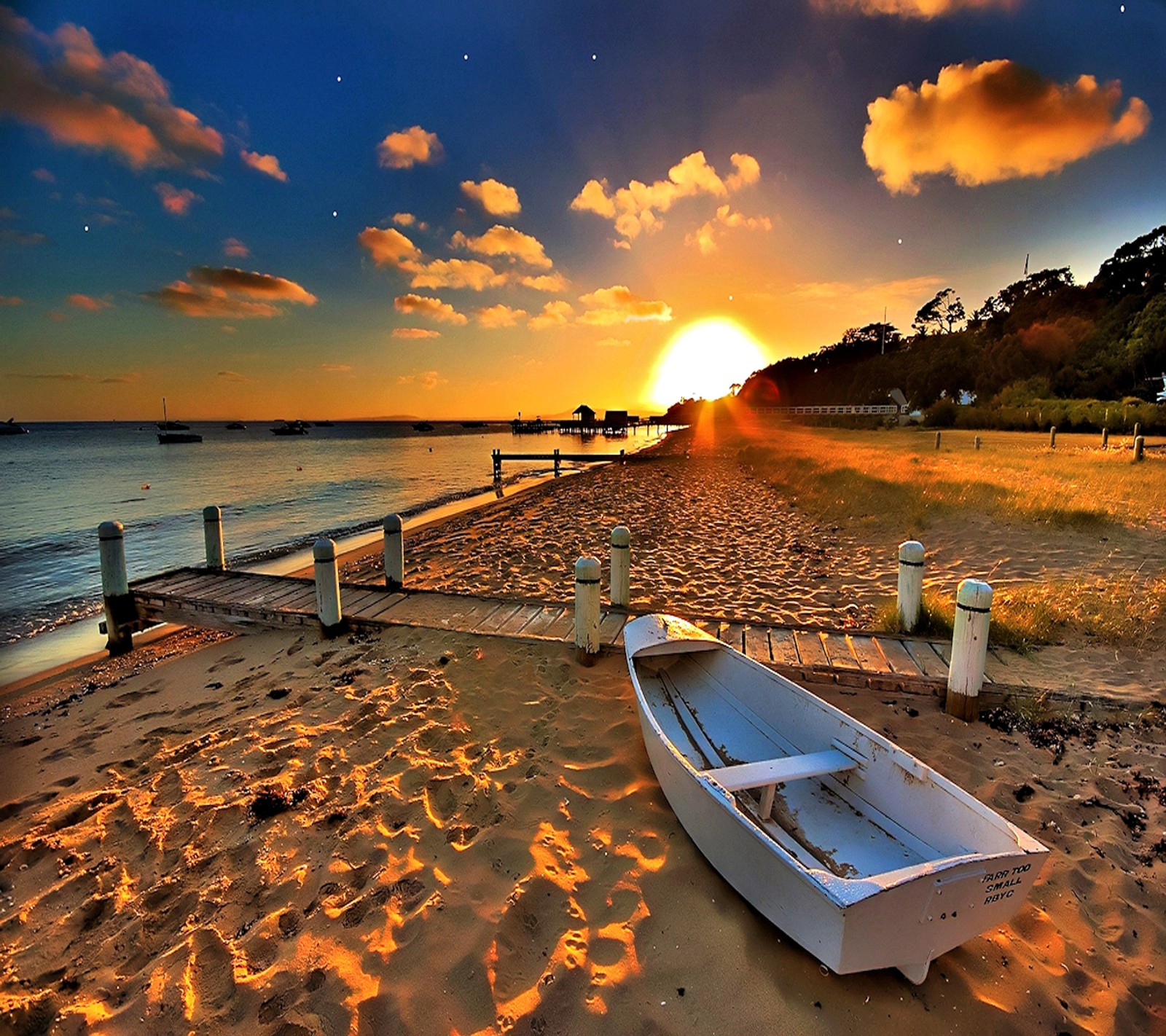 Há um barco na areia na praia ao pôr do sol (paisagem bonita, por do sol)