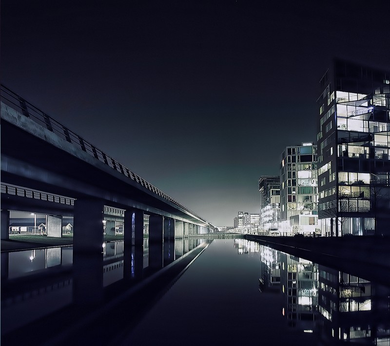 Nighttime view of a canal with buildings and a bridge in the background (android, htc one, kuwait, landscape, mughalmab)