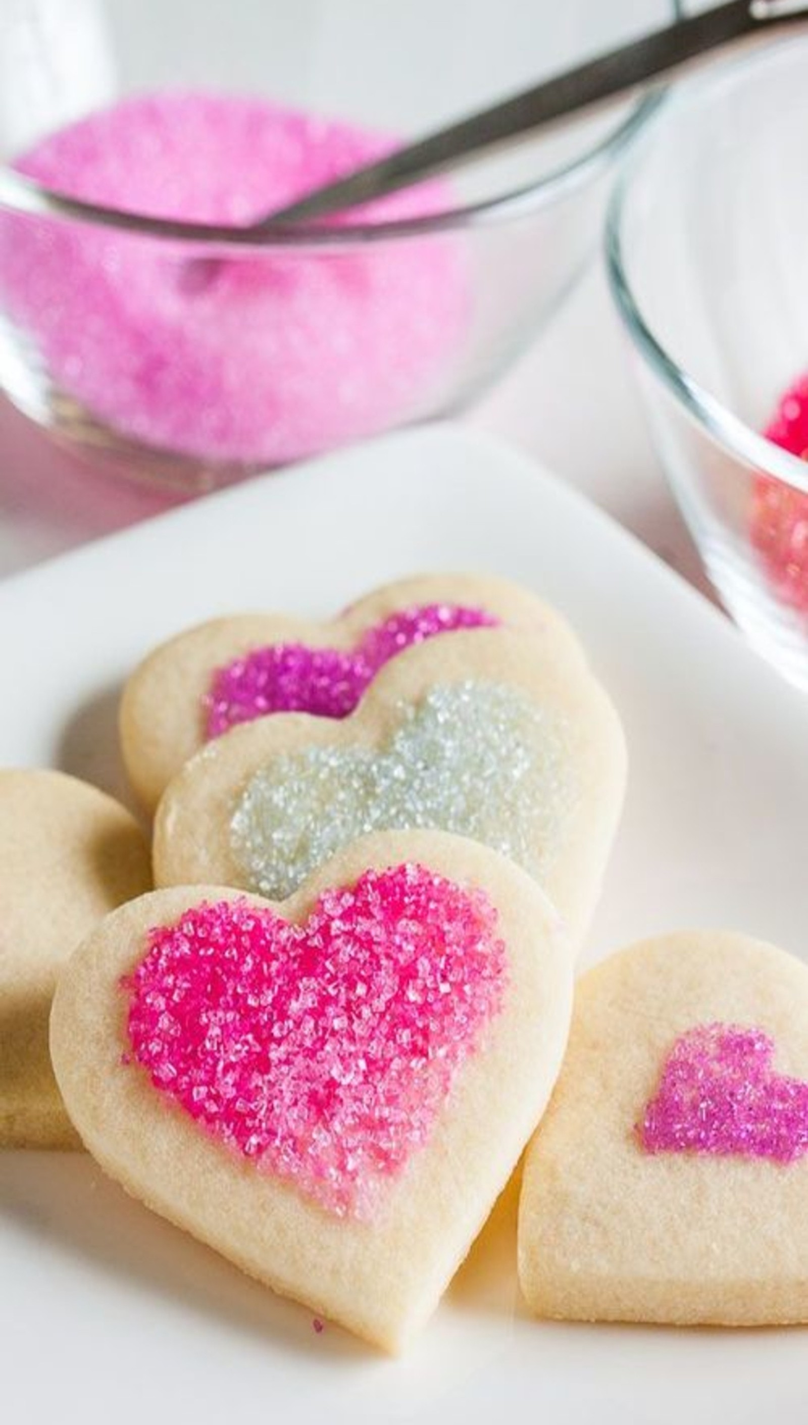 Mehrere zuckerkekse mit rosa und lila streuseln auf einem teller (süßigkeiten, zucker, wall e, walle)