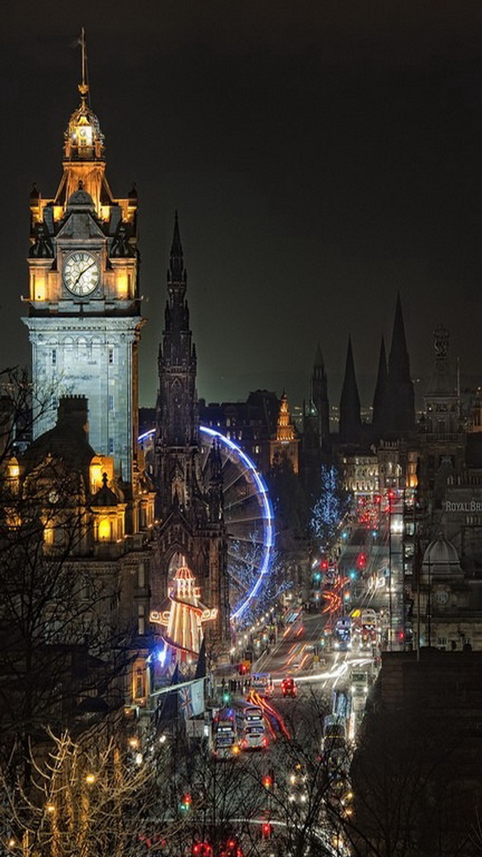 Uma vista aráfe de uma cidade à noite com uma roda-gigante e uma torre do relógio (cidade, edimburgo, edinburgh, escócia)