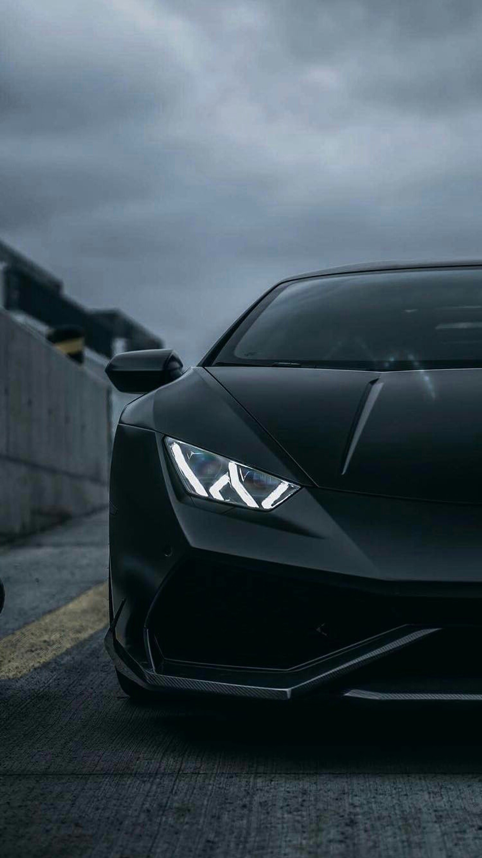 A close up of a black sports car parked on a road (black, front, huracan, lambo, lamborghini)