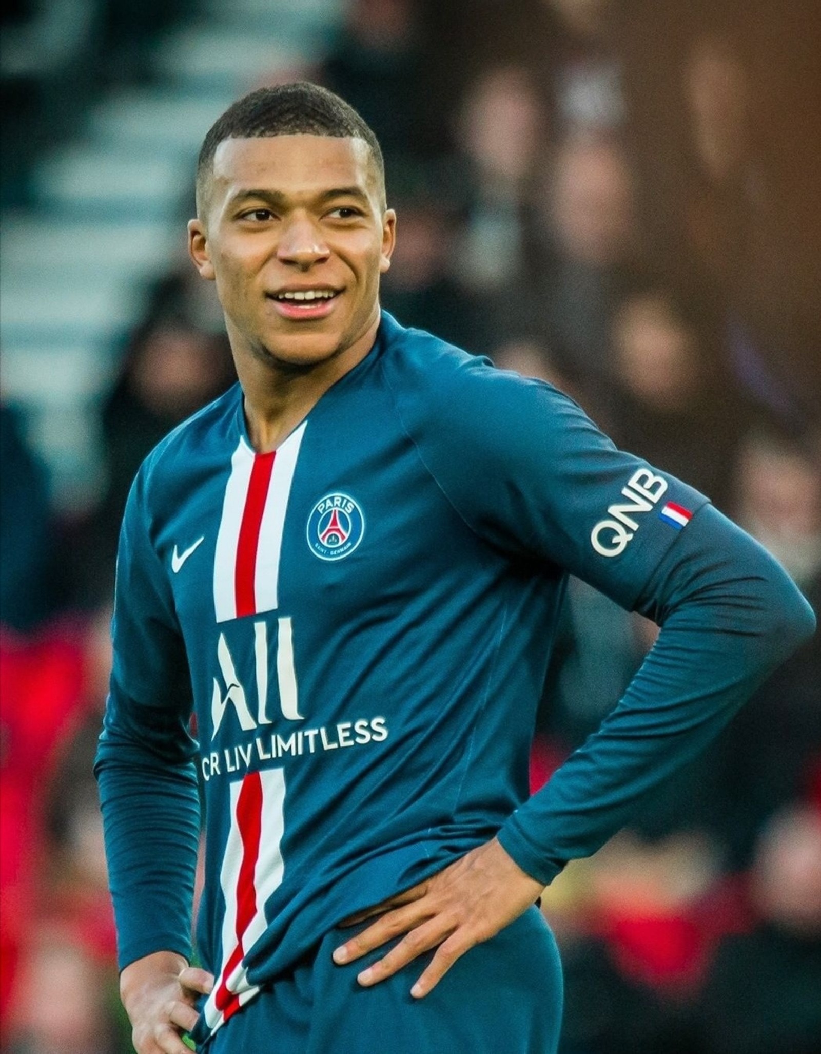 Jugador de fútbol en uniforme azul de pie en el campo con una multitud al fondo (donatello, fútbol, francia, futbol, kylian)