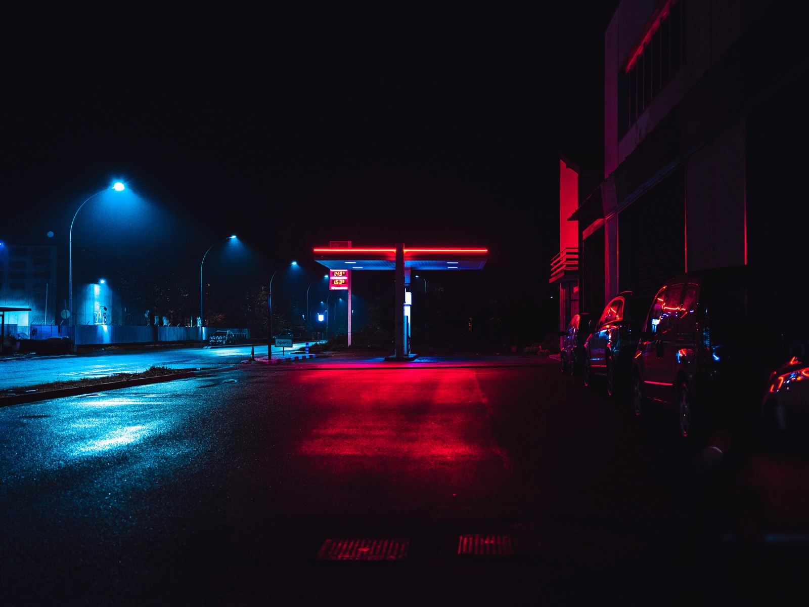 Una imagen aérea de una gasolinera de noche con luces rojas (noche, rojo, ligero, oscuridad, neón)