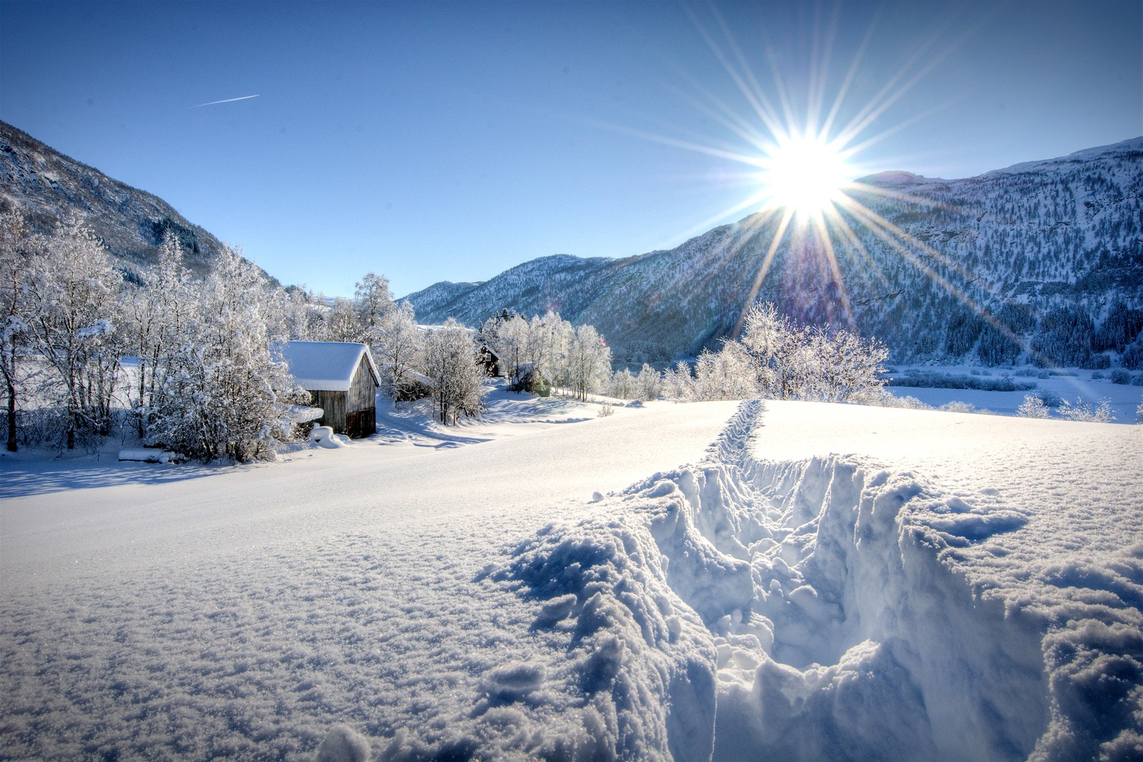 Aussicht auf ein verschneites feld mit einem haus in der ferne (schnee, winter, berg, gebirgige landformen, gebirgskette)