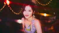 Sana from TWICE radiates charm and elegance in a vibrant setting, embodying the theme of "Alcohol-Free" from the "Taste of Love" album.