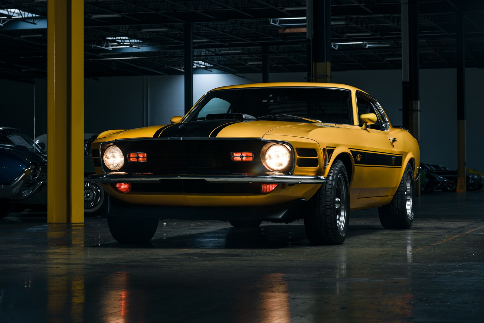 Yellow car in a garage with other cars in the background (ford mustang mach 1, 8k, muscle cars, 5k, classic cars)