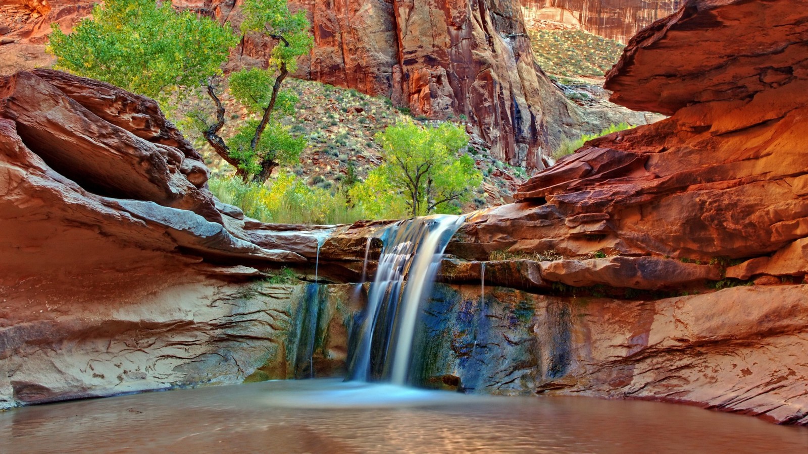 Uma cachoeira caindo em uma piscina em um cânion cercado por rochas (cachoeira, natureza, recursos hídricos, água, estreitos)