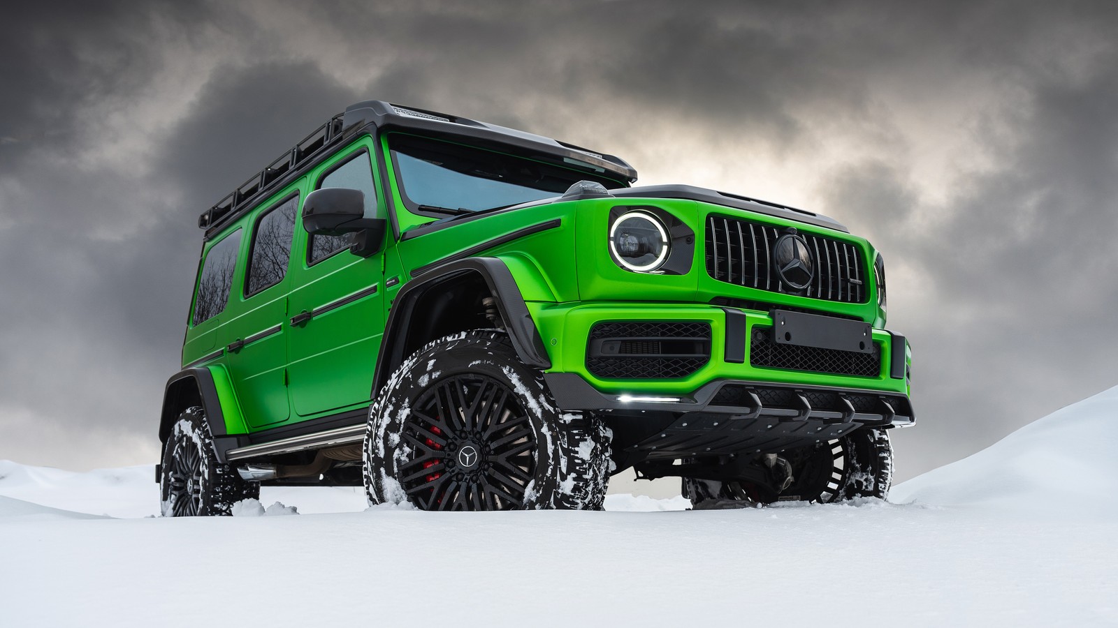 Nahaufnahme eines grünen jeeps, der durch ein schneebedecktes feld fährt (mercedes amg g 63, g wagon, schneebedeckt, autos, 4k hintergrund)