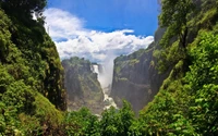 Chute d'eau majestueuse se déversant à travers des vallées de forêt tropicale luxuriante