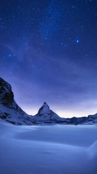 Majestuosa montaña cubierta de hielo bajo un cielo estrellado