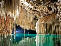 Caverna azul encantadora com estalactites refletidas em águas calmas