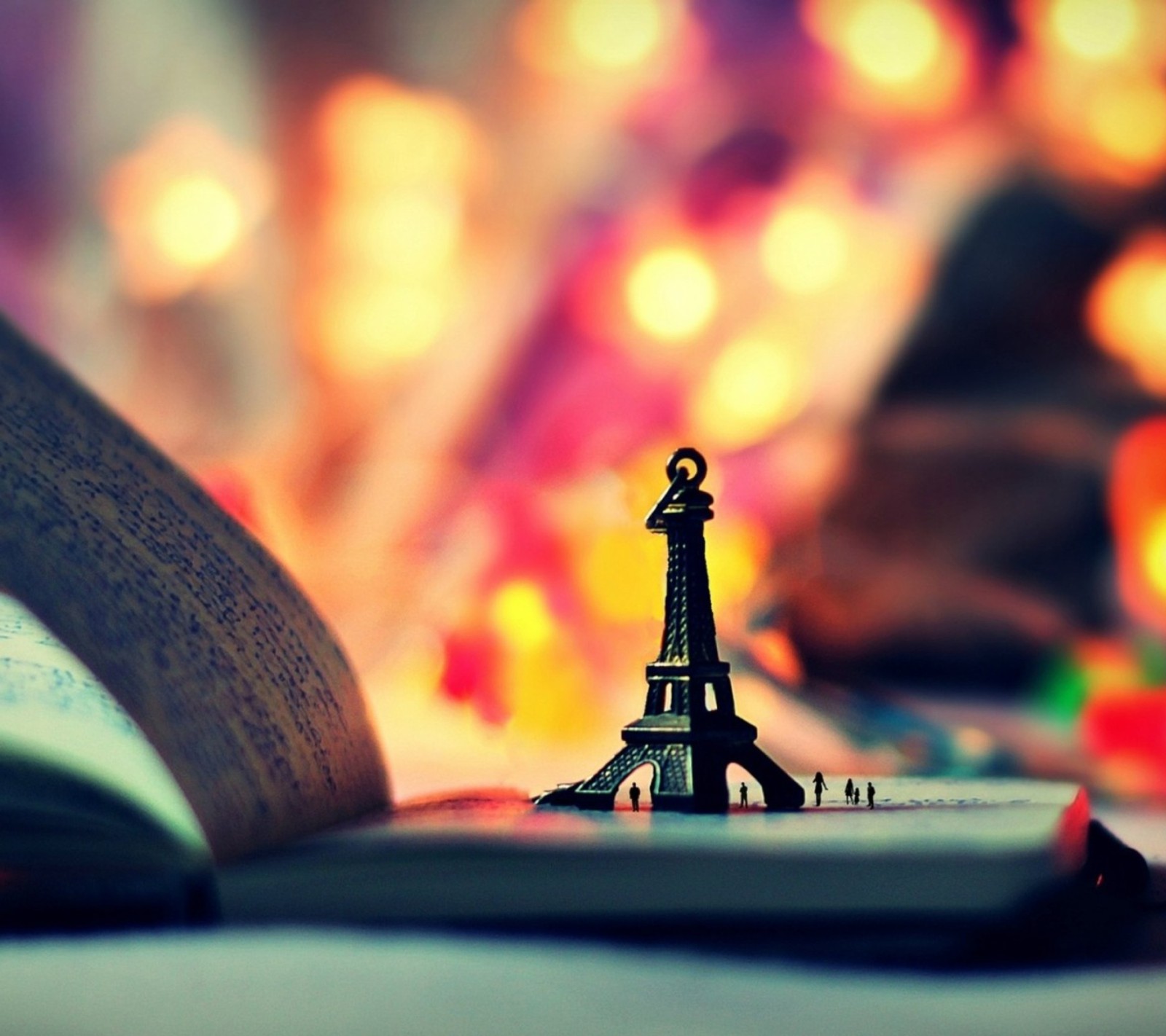 Il y a un petit jouet d'une tour sur un livre (bokeh effect, tour eiffel, lumière)